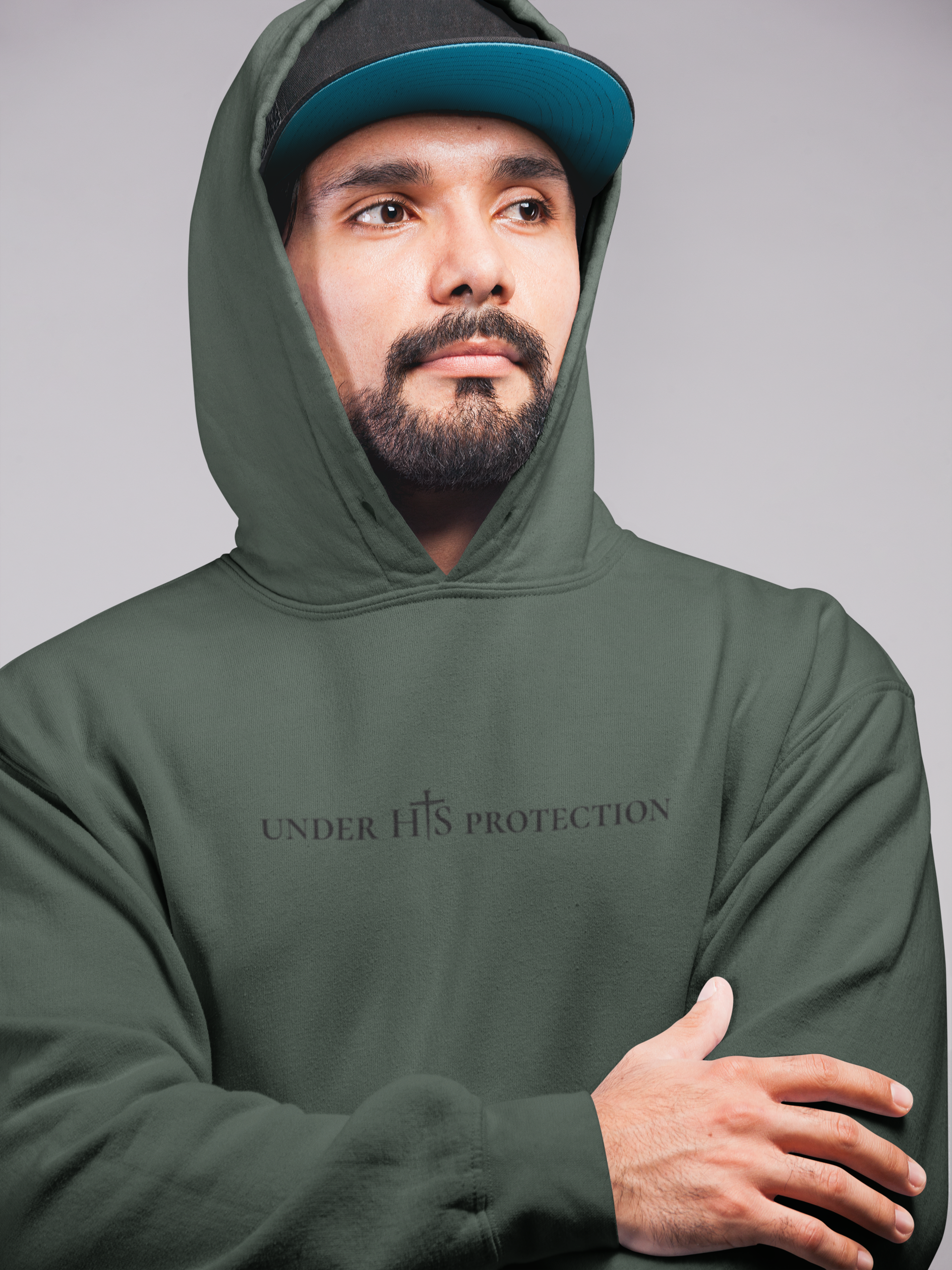Person wearing “Under His Protection” hoodie by MyCreed with scripture design on front.