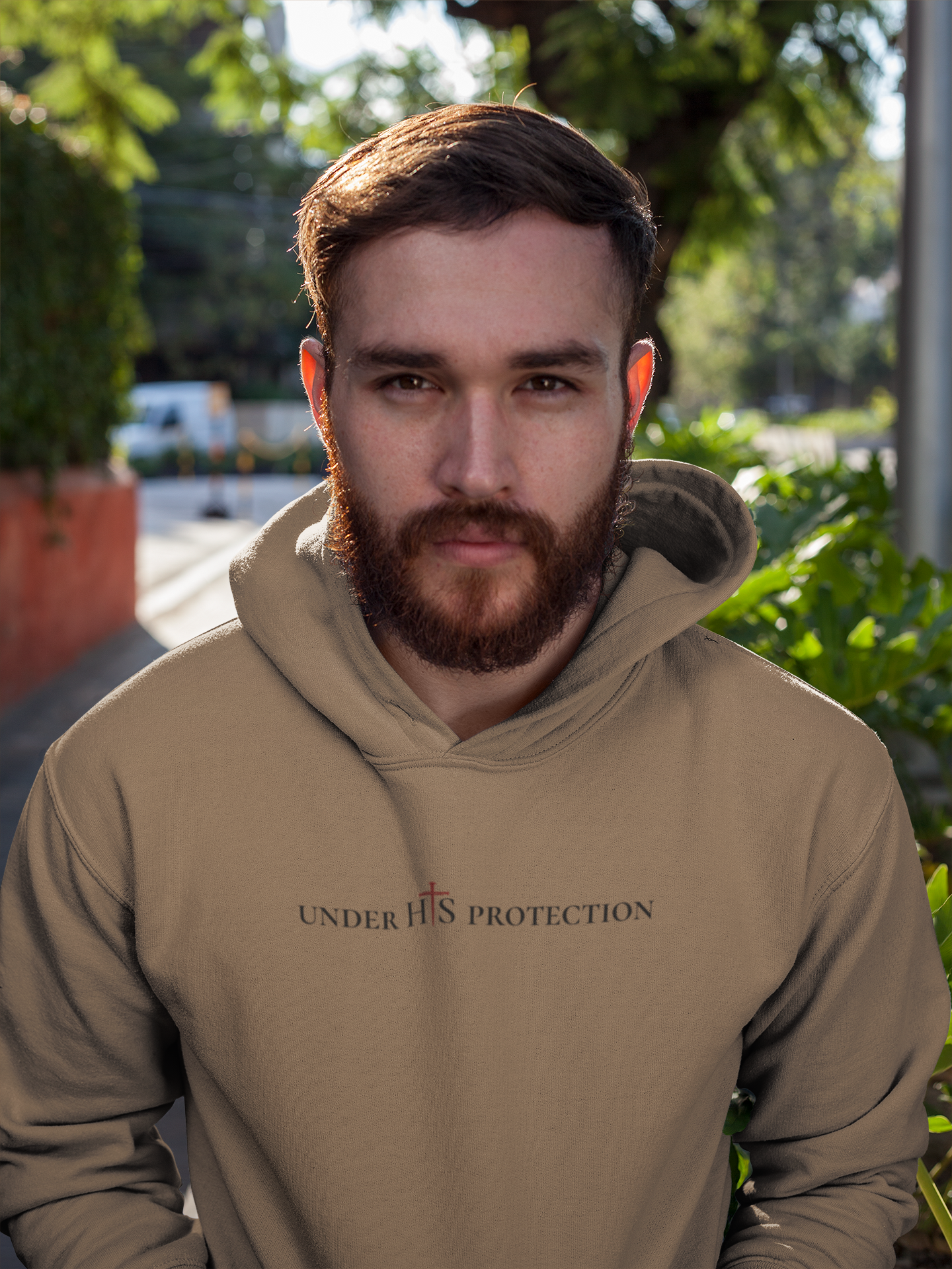 Person wearing “Under His Protection” hoodie by MyCreed with scripture design on front.