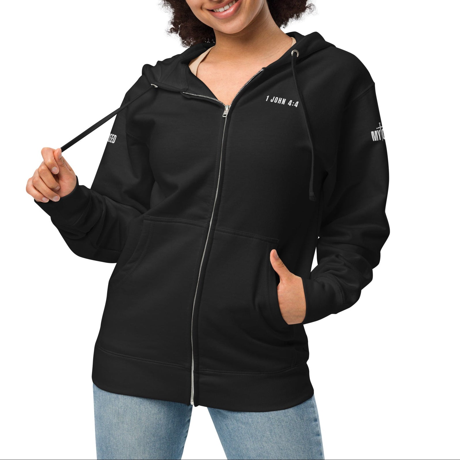 Black zip-up hoodie on female model, front view with left chest “1 JOHN 4:4” by MyCreed™