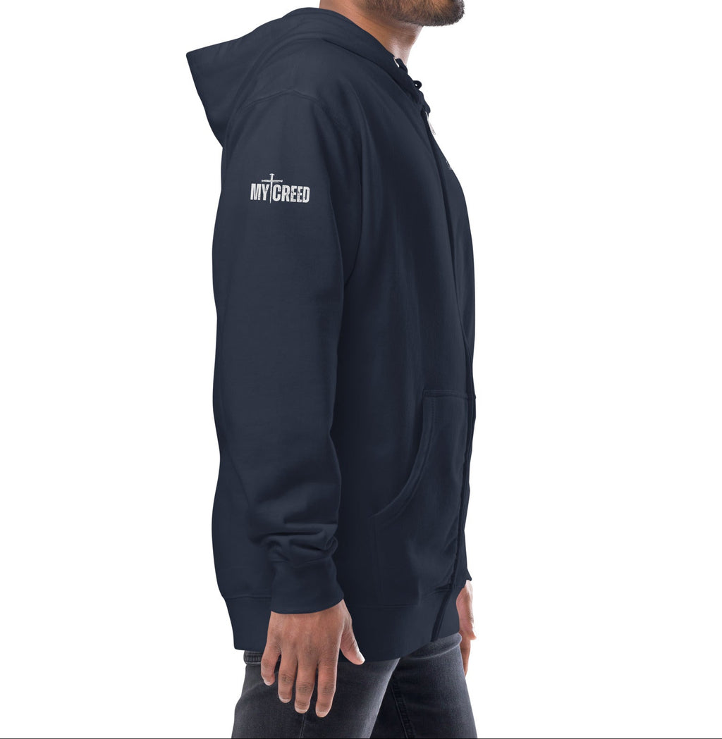 Navy zip-up hoodie on model, right side view showing left chest “1 JOHN 4:4” by MyCreed™