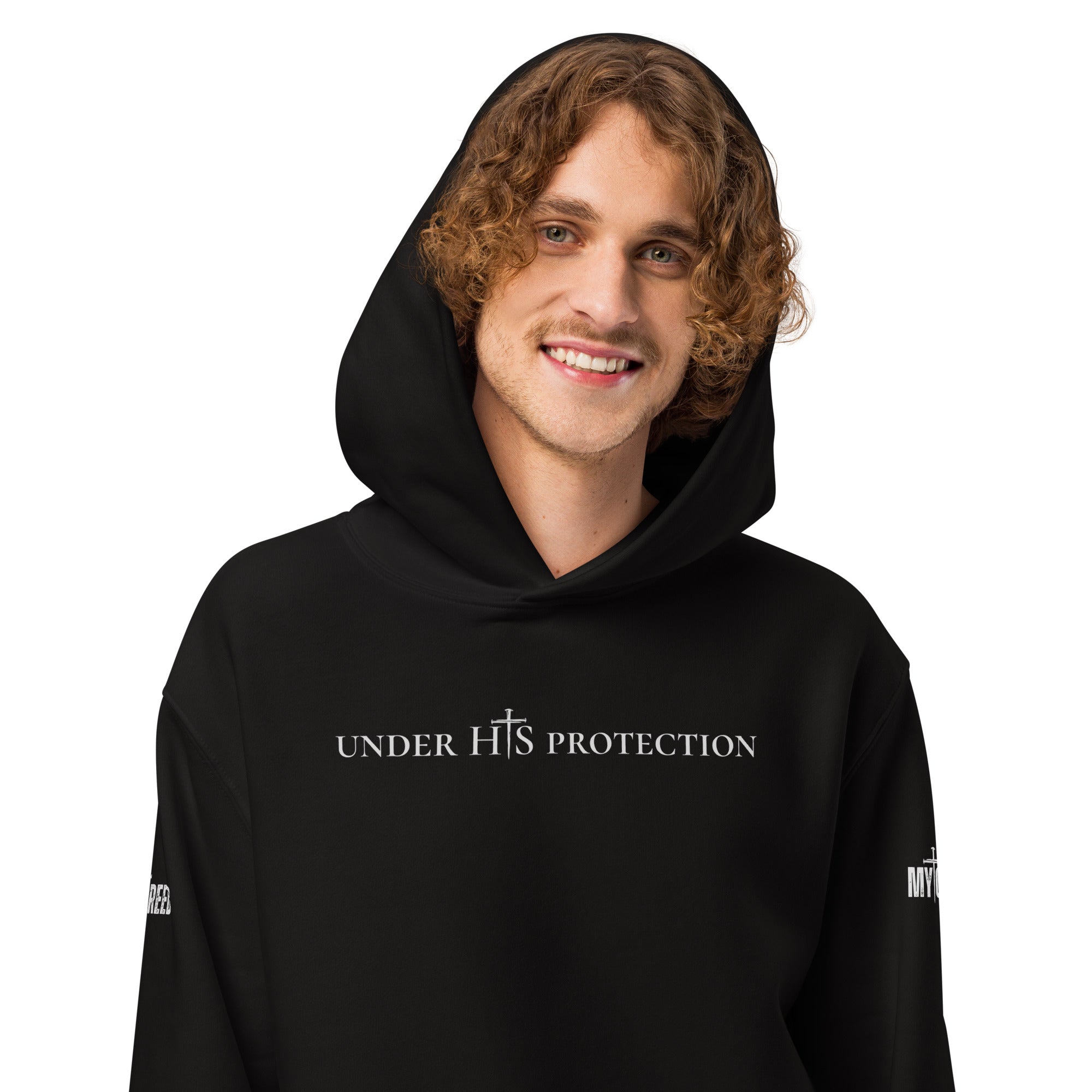 Portrait lifestyle image of model wearing black “Under His Protection” hoodie, by MyCreed™