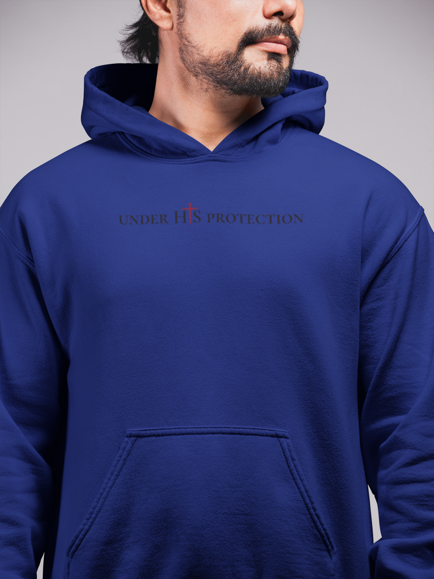 Person wearing “Under His Protection” hoodie by MyCreed with scripture design on front.